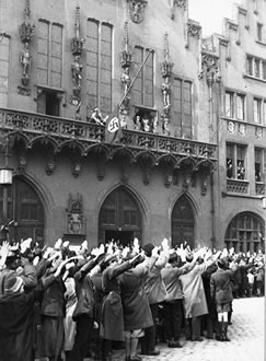 Hissung der
                      Hakenkreuzfahne am Rmerberg im Mrz 1933, und die
                      Menschenmenge macht den strammen Hitlergruss