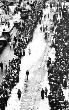 Der Rossmarkt von
                        Frankfurt am Main nach Kriegsende 1945 mit
                        Schlangestehen und mit den Geleisen einer
                        Trmmerbahn