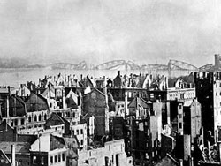 Mainz in
              Ruinen und eine zerstrte Rheinbrcke im Hintergrund Mrz
              1945 [1]