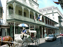 New Orleans French Quarter: Houses in
                          colonial style on Bourbon Street, with coach
                          for tourists in the colonial manorial racist
                          color: white.