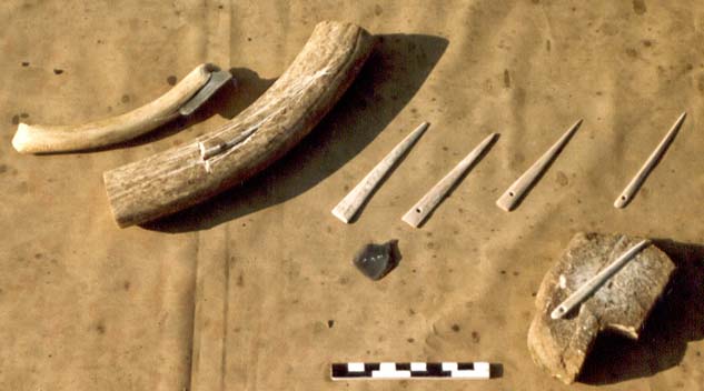 Die
                    Herstellung einer Knochennadel aus Knochen, Klinge
                    und spitzem Stein