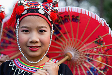 M�dchen der Meo (Hmong) in Thailand in
                        traditionellen Kleidern und mit einem roten
                        Regenschirm