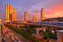 กรุงเทพมหานครที่มีรถไฟฟ้าและมีการขูดท้องฟ้าด้วยท้องฟ้ายามเย็น