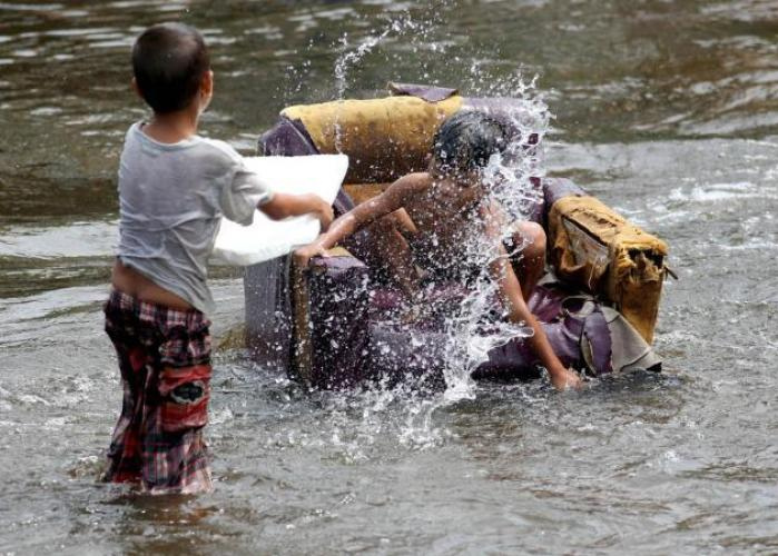 S�dthailand, Kinder im
                  Hochwasser mit einem schwimmenden Sofasessel,
                  27.Dezember 2014
