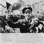 Gagarin en Praga: Gagarin con flores
                        moviendo una banderita checa y otra banderita
                        sovitica
