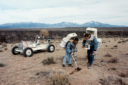 Entrenamiento para Apolo 15, foto de la
                        NASA S71-23772, una excursin EVA en un
                        territorio similar a la luna en Taos al margen
                        del Ro Grande (Nueva Mxico): Irwin toma
                        pruebas del suelo con una pala, Scott tiene una
                        bolsa para la prueba. Al fondo hay el carro
                        lunar de entrenamiento "Grover",
                        11-12/03/1971, fecha del catlogo 03/11/1971