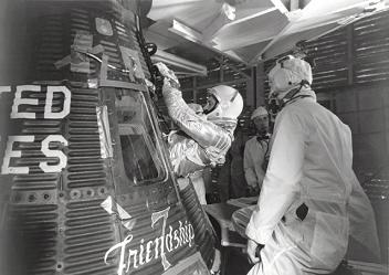 Glenn entering his Mercury high
                            atmosphere capsule "Friendship 7"
                            (propaganda says: "space
                            capsule")