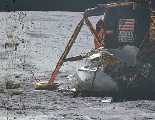 Apollo 16, Foto Nr.
                                    AS16-116-18577: Da liegt Mll neben
                                    der "Mondlandefhre", und
                                    die Werbetafel "United
                                    States" ist zum teil
                                    durchgestrichen, und es scheint so,
                                    dass der Schatten des sichtbaren
                                    Landefusses der
                                    "Mondlandefhre" fehlt.