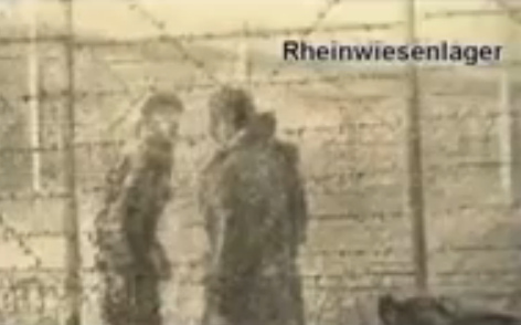 Rhine meadow camp, two persons at a barbed
                        wire fence