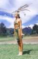 Woman in a costume of Quimbaya natives
                            with feathers and a bra of gold